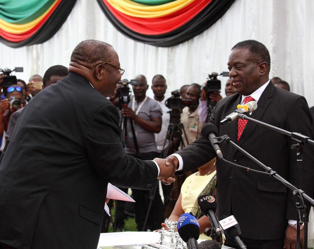 Obert Mpofu shakes hands with Emmerson Mnangagwa