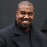 Kanye West smiling in a black peacoat. Kanye West is now legally known as "Ye," according to a judge.