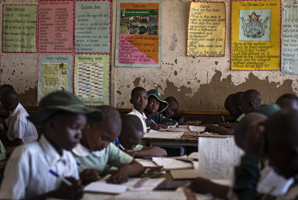 School children attend a ZIMSEC class in the Shona language on the first day of term at the Vimbai Primary School in Norton, west of the capital Harare, in Zimbabwe Tuesday, Sept. 10, 2019. Former president Robert Mugabe, who enjoyed strong backing from Zimbabwe's people after taking over in 1980 but whose support waned following decades of repression, economic mismanagement and allegations of election-rigging, is expected to be buried on Sunday, state media reported. (AP Photo/Ben Curtis)