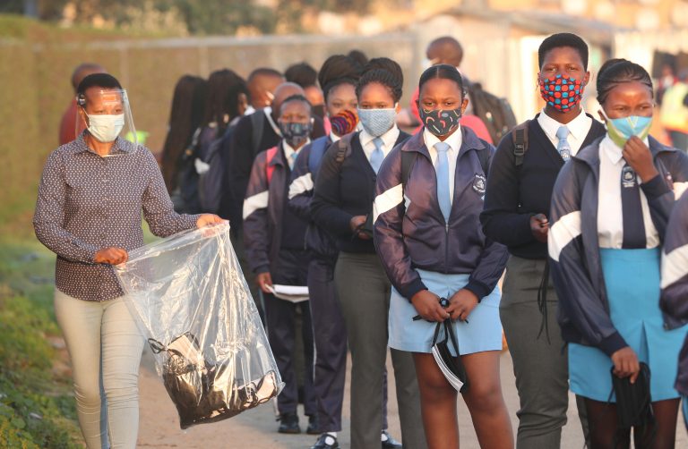 A teacher distributes masks to students as schools begin to reopen after the coronavirus disease (COVID-19) lockdown in Langa township in Cape Town, South Africa June 8, 2020. REUTERS/Mike Hutchings/File Photo
