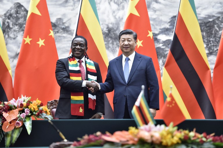 Zimbabwe's President Emmerson Mnangagwa (L) shakes hands with Chinese President Xi Jinping as they pose for the media after a signing ceremony at the Great Hall of the People in Beijing on April 3, 2018. Mnangagwa is on a visit to China to seek economic support from a major partner that previously backed his ousted predecessor Robert Mugabe. / AFP PHOTO / POOL / Parker Song