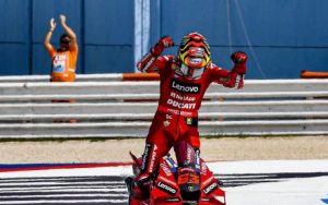 Ducati rider Pecco Bagnaia celebrating a win after completing a MotoGP race.