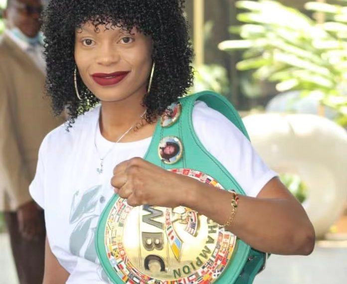 Zimbabwean boxer Kudakwashe Chiwandire posing with her WBC Interim Super bantamweight title.