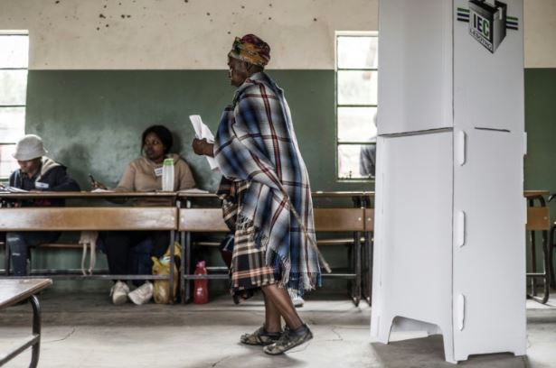 A voter leaves the polling booth, holding her ballot, in the town of Koro-Koro, Lesotho