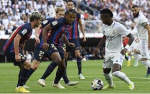 Real Madrid forward Vinicius Junior vies with Barcelona's Sergi Roberto (L) and Jules Kounde (C) during the Spanish League football match between Real Madrid CF and FC Barcelona at the Santiago Bernabeu stadium on 16 October 2022.