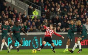 Brentford midfielder Mathias Jensen (C) stretches for the ball during the English Premier League football match between Brentford and Liverpool at Gtech Community Stadium in London on 2 January 2023.