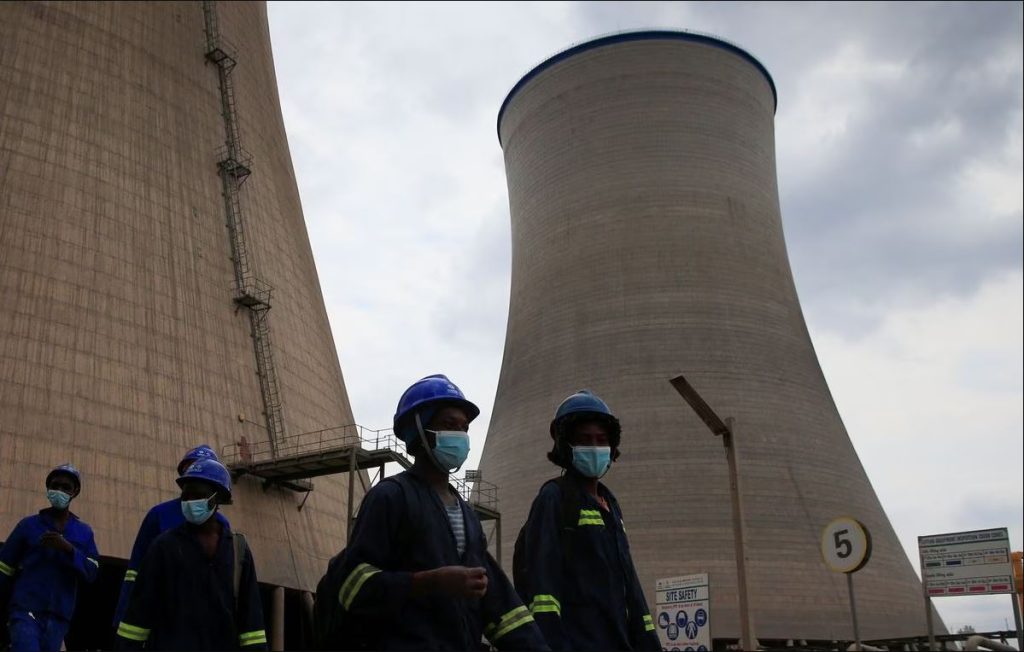 ZPC workers walk beneath cooling towers at Hwange Power station's Phase 8, currently under construction, in Hwange, Zimbabwe, October 19, 2021.