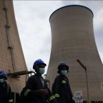 ZPC workers walk beneath cooling towers at Hwange Power station's Phase 8, currently under construction, in Hwange, Zimbabwe, October 19, 2021.