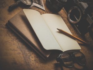 A design photo of book writing notepad and a pen.