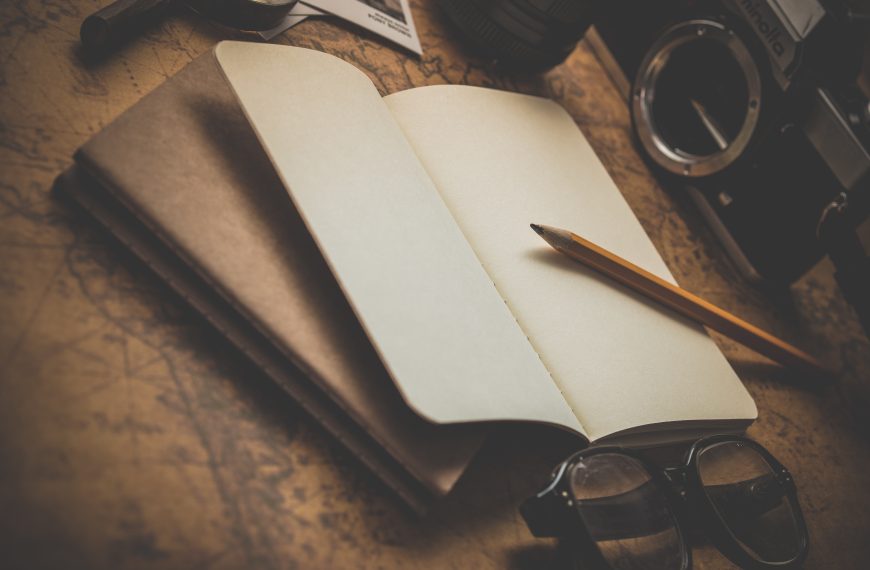 A design photo of book writing notepad and a pen.