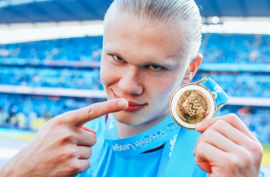 Erling Haaland shows off his Premier League medal after inspiring Manchester City to a routine league title.