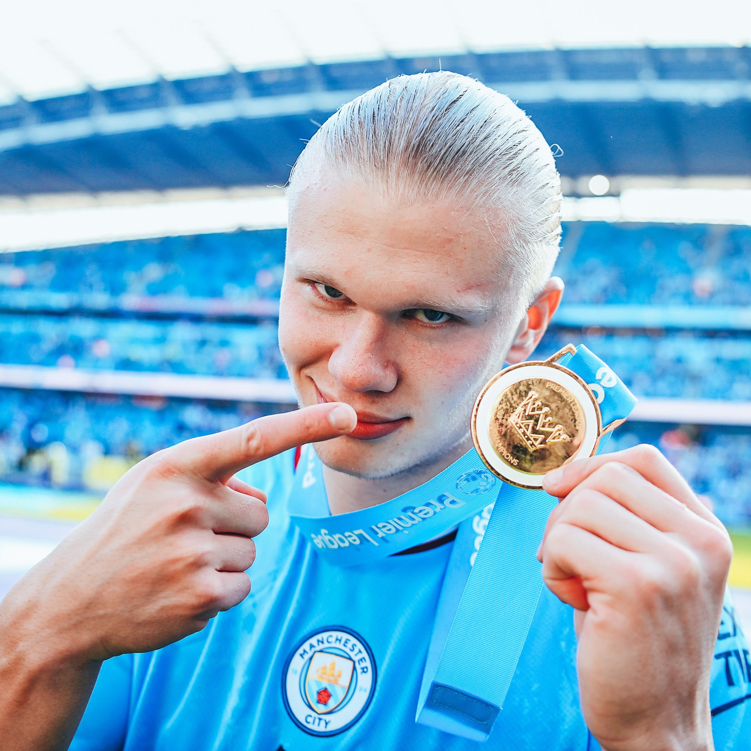Erling Haaland shows off his Premier League medal after inspiring Manchester City to a routine league title.