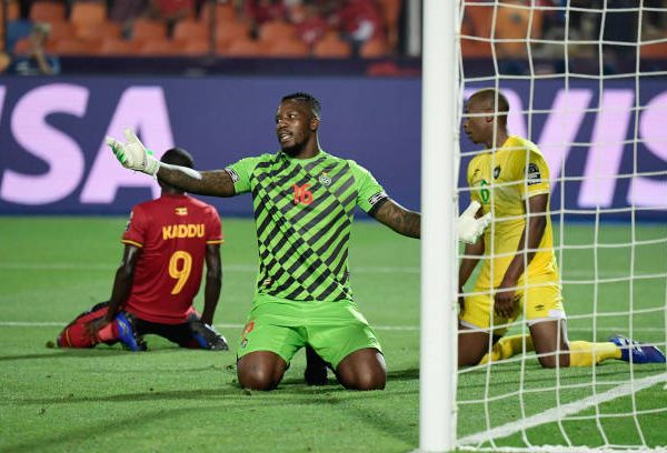 Zimbabwe's goalkeeper George Chigova (2nd-R) reacts next to Uganda's forward Patrick Kaddu (1st-L) after winning a one on one during the 2019 Africa Cup of Nations (CAN) football match between Uganda and Zimbabwe at the Cairo International Stadium on June 26 , 2019.