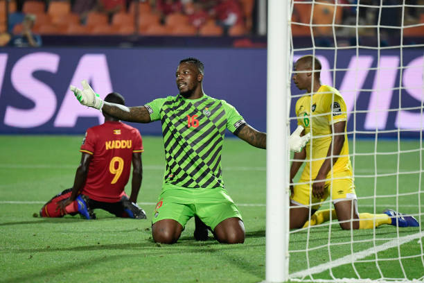 Zimbabwe's goalkeeper George Chigova (2nd-R) reacts next to Uganda's forward Patrick Kaddu (1st-L) after winning a one on one during the 2019 Africa Cup of Nations (CAN) football match between Uganda and Zimbabwe at the Cairo International Stadium on June 26 , 2019.