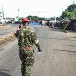 A soldier with the Sierra Leonean military police greets and man along an empty road in Freetown on November 26, 2023. A military armoury in Sierra Leone's capital Freetown came under attack on Sunday, the government said, as it imposed an immediate national curfew.