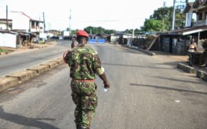 A soldier with the Sierra Leonean military police greets and man along an empty road in Freetown on November 26, 2023. A military armoury in Sierra Leone's capital Freetown came under attack on Sunday, the government said, as it imposed an immediate national curfew.